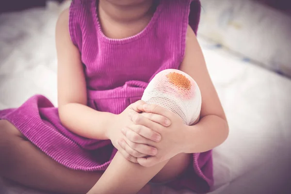 Child injured. Wound on the child's knee with bandage. Vintage tone — Stock Photo, Image