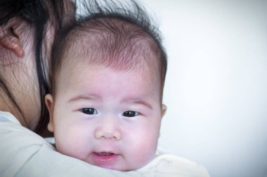 Anne ve bebek, annesinin omzuna dinlenme güzel Asyalı kız