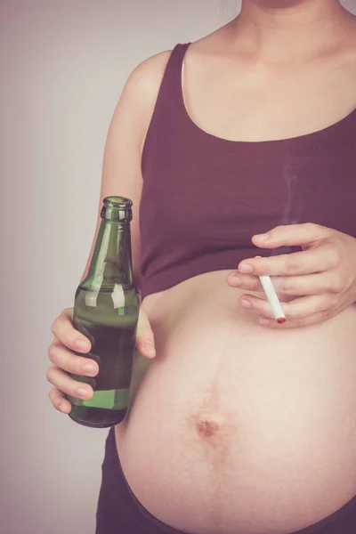 Pregnancy with cigarette and alcohol. Pregnant unhealthy motherhood concept.