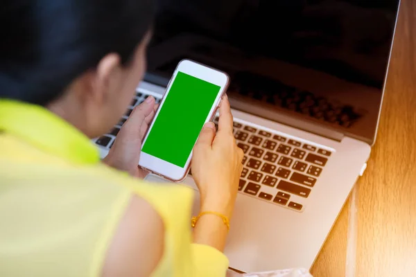 Woman's hands using cell phone and laptop computer. — Stock Photo, Image