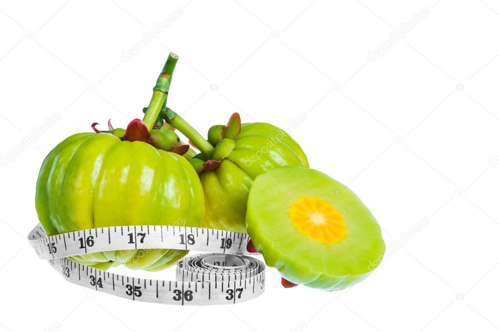 Garcinia cambogia fresh fruit with tapeline, isolated on white. 