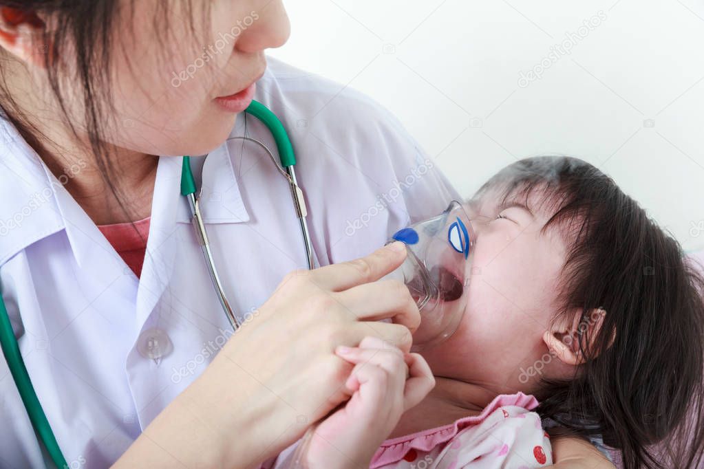 Asian girl having respiratory illness helped by pediatrician. Child crying.