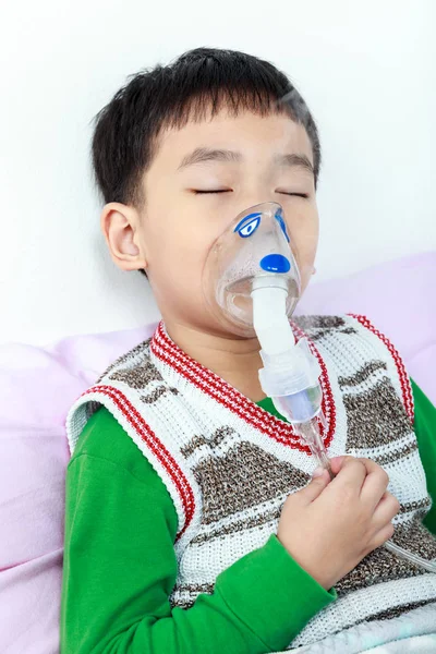 Primo piano asiatico bambino chiusura occhi e tiene una maschera vapore inalatore — Foto Stock