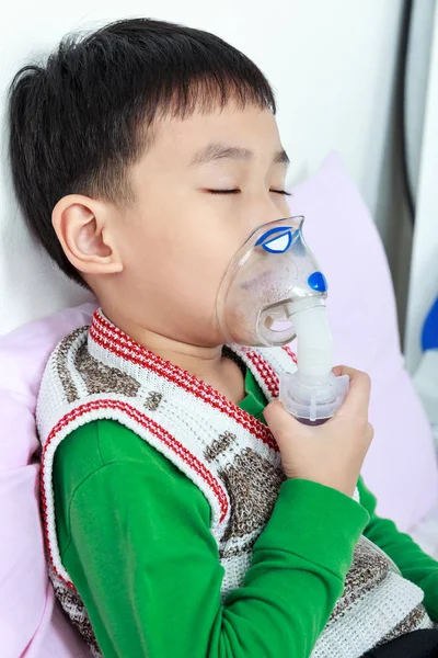 Closeup asian child closing eyes and holds a mask vapor inhaler — Stock Photo, Image
