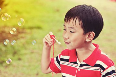 Asyalı çocuk yaz park, doğa arka plan sabun köpüğü üfleme