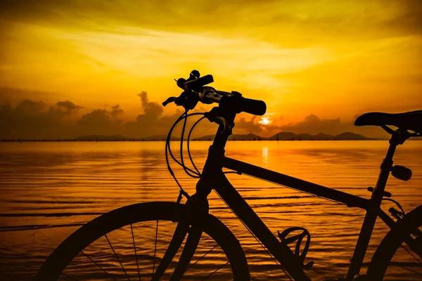 Fahrradsilhouette am Strand gegen bunten Sonnenuntergang im Meer. — Stockfoto