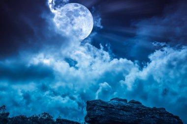 Boulder against blue sky with clouds and beautiful full moon at  clipart