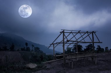 Küçük bambu kulübe ve dağ zirveleri. Gece gökyüzü ve ay ile ağaçlarının Silhouettes