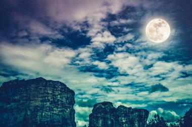 Boulder gökyüzü bulutlar ve güzel dolunay ile karşı. Açık