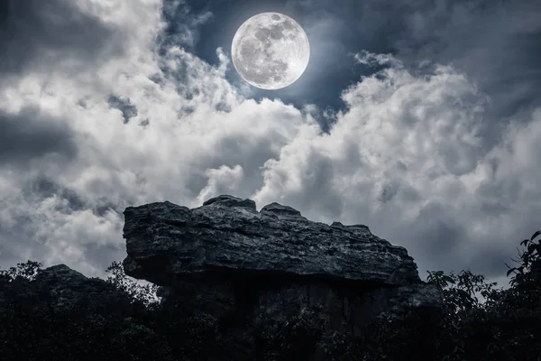 Boulder contra el cielo con nubes y hermosa luna llena en la noche — Foto de Stock