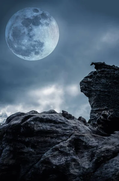 Boulder contra el cielo con nubes y hermosa luna llena en la noche — Foto de Stock