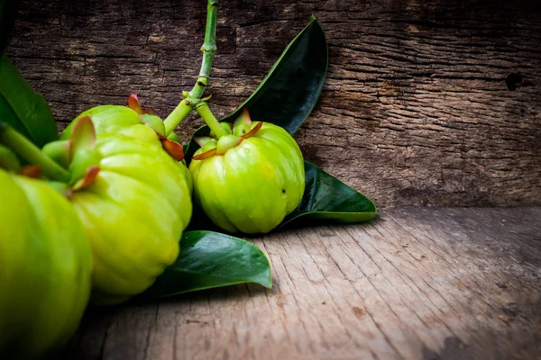 Garcinia cambogia taze meyve ahşap arka plan üzerinde kapat. 