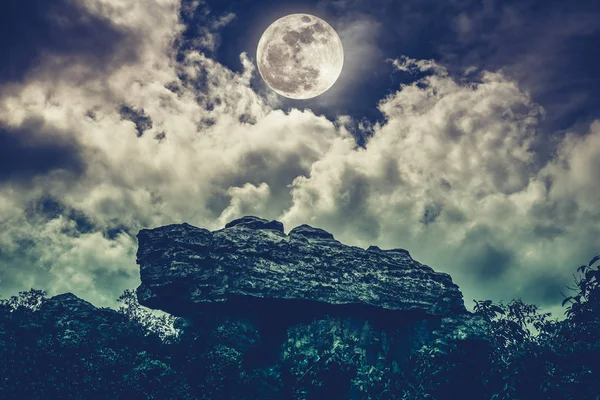 Boulder contra el cielo con nubes y hermosa luna llena. Exterior — Foto de Stock