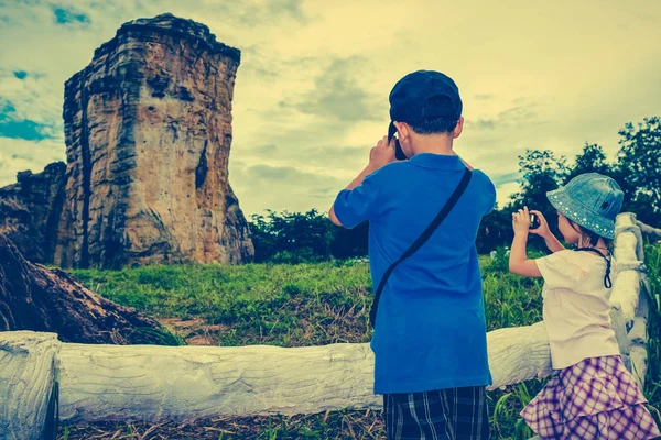 Los niños asiáticos toman fotos por cámara. Proceso cruzado y tono vintage . — Foto de Stock