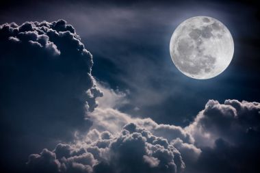 Gece gökyüzü bulutlar ve parlak dolunay ile parlak.  