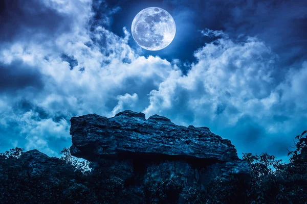 Boulder przeciw błękitne niebo z chmur i piękny Księżyc w nocy. — Zdjęcie stockowe