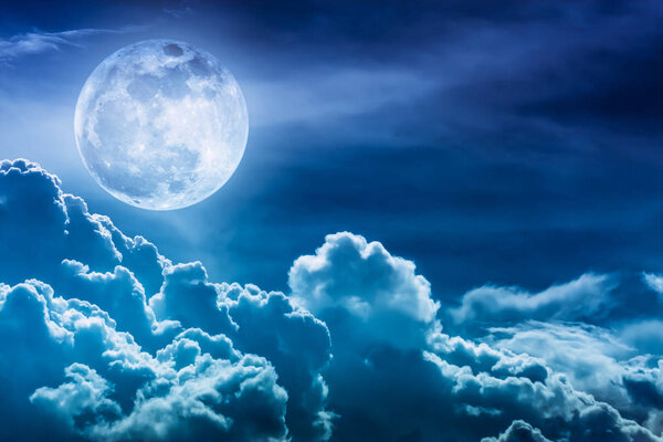 Attractive photo of blue background nighttime sky and bright full moon with shiny. Nightly sky with beautiful full moon and cloudy. Outdoors at night. The moon were NOT furnished by NASA.