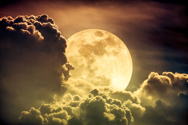Super moon. Attractive photo of background night sky with cloudy and bright full moon. Nightly sky with beautiful full moon behind clouds. Sepia tone. The moon were NOT furnished by NASA.