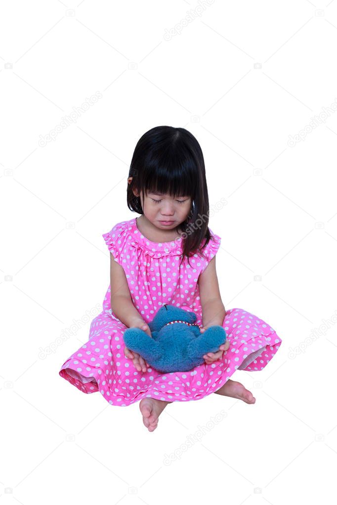 Asian girl sitting with toy bear, sadden and crying. Isolated on white background. 