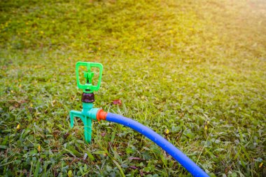 Bahçe. Çim yeşil çimenlerin üzerinde otomatik sprinkler. Açık.