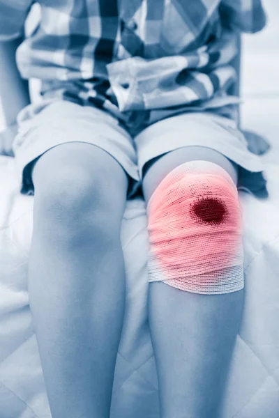 Enfant blessé. Blessure au genou de l'enfant avec bandage. Santé humaine et médecine concept . — Photo
