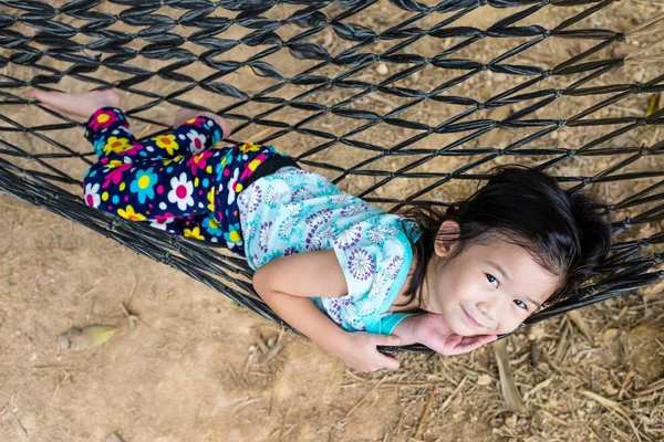 Dziecko ciesząc się i zrelaksować się w hamaku, odkryty letni dzień. — Zdjęcie stockowe