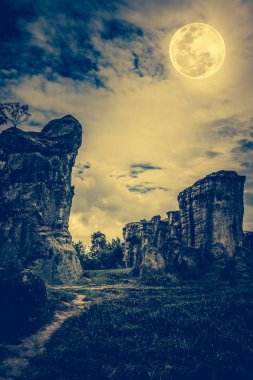 Bulutlar ve güzel Dolunay geceleri gökyüzüne karşı kayalar