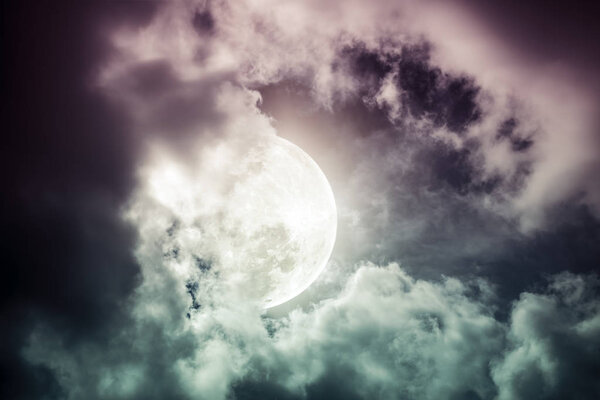 Attractive photo of a nighttime sky with cloudy and bright moon. Beautiful nature use as background. Outdoors. Cross process tone. The moon were NOT furnished by NASA.