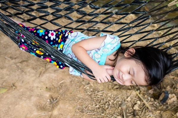 Szczęśliwe dziecko ciesząc się i zrelaksować się w hamaku, słodki sen i uśmiechając się. — Zdjęcie stockowe