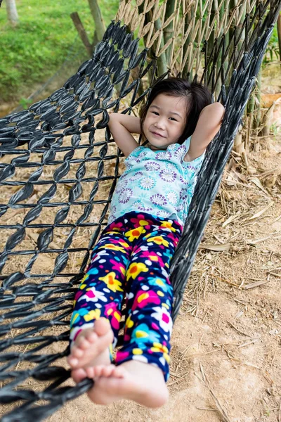 Criança alegre desfrutando e relaxando na rede, ao ar livre no dia de verão . — Fotografia de Stock