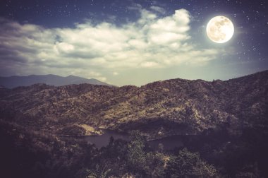 Mavi karanlık gece gökyüzü bulutlu ve birçok yıldız ile peyzaj. 
