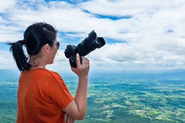 Asyalı kadın ile dijital fotoğraf makinesi, gündüz yaz gününde, açık.