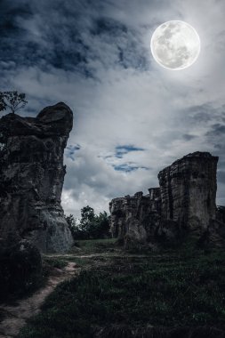 Kayalar ile bulutlar ve güzel dolunayda gece gökyüzü karşı.