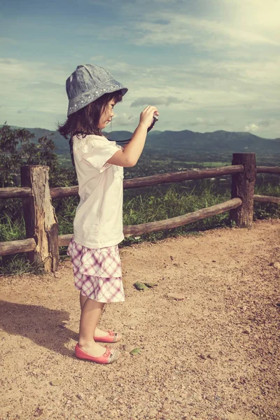 Feliz chica asiática sonriendo y relajándose al aire libre durante el día, viajar de vacaciones . — Foto de Stock