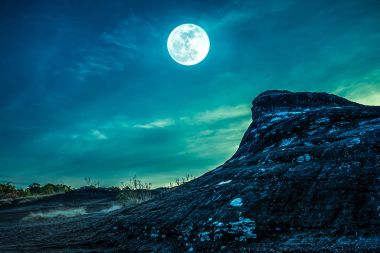 Gökyüzü ve dolunay vahşi alanı üzerindeki kayaya peyzaj