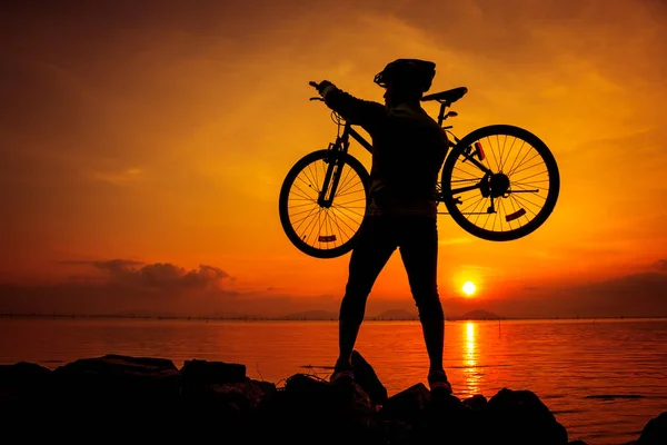 健康的生活方式。骑自行车的人携带他的自行车的剪影 — 图库照片