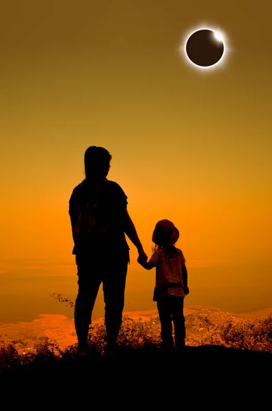 Удивительное научное природное явление. Полное солнечное затмение с эффектом бриллиантового кольца, светящимся на оранжевом небе на вершине горы . — стоковое фото