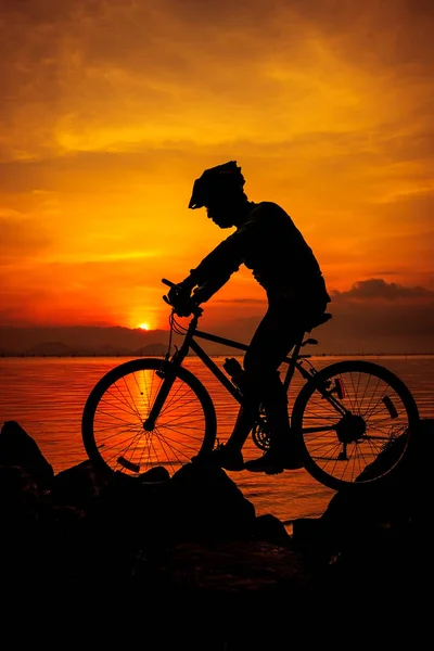 Uno stile di vita sano. Silhouette del ciclista in sella alla bici al mare . — Foto Stock