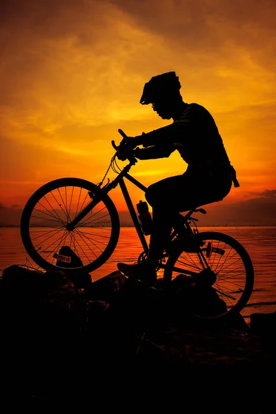 Estilo de vida saudável. Silhueta de ciclista andando de bicicleta à beira-mar . — Fotografia de Stock