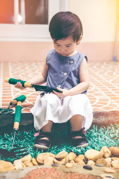 Bambino asiatico con attrezzatura da giardinaggio. All'aperto per bambini. tono vintage . — Foto Stock