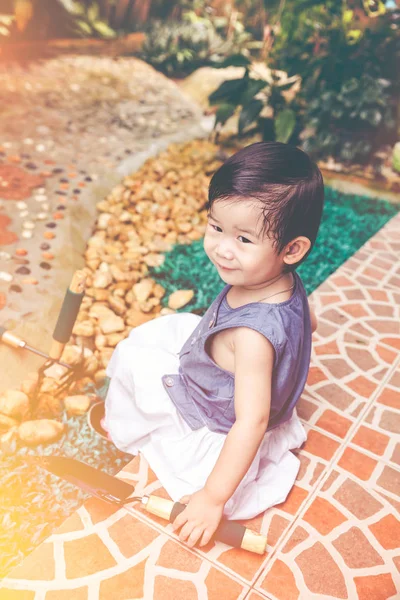 Azjatycki dziecko ze sprzętem ogrodniczym. Na zewnątrz dla dzieci. Dźwięk w Vintage. — Zdjęcie stockowe