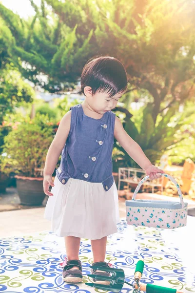 Criança asiática com pá e cesta preparada para jardinagem. Ao ar livre . — Fotografia de Stock