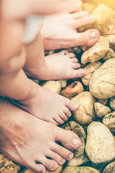 Il piede del bambino impara a camminare su ciottoli con il padre insieme su s — Foto Stock