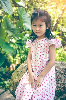 Gülümseyen ve güneş ışığı ile Park'ta rahatlatıcı sevimli Asyalı çocuk,