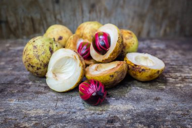 Küçük Hindistan cevizi myristica ahşap arka plan üzerinde kokulu tohum plasenta gibi kapaklı.