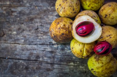 Küçük Hindistan cevizi myristica ahşap arka plan üzerinde kokulu tohum plasenta gibi kapaklı.