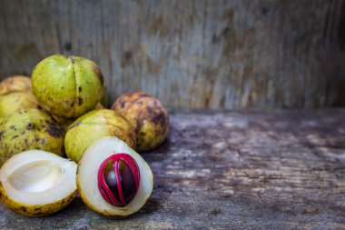 Küçük Hindistan cevizi myristica ahşap arka plan üzerinde kokulu tohum plasenta gibi kapaklı.