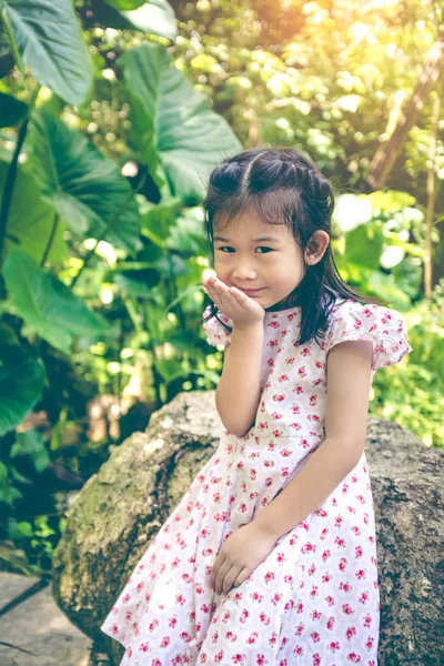 Entzückendes asiatisches Kind lächelt und entspannt im Park mit Sonnenlicht, — Stockfoto