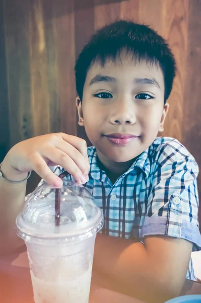 英俊的亚洲孩子他午饭后微笑与牛奶凉爽。老式的影响口气. — 图库照片