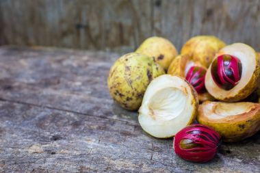 Küçük Hindistan cevizi myristica ahşap arka plan üzerinde kokulu tohum plasenta gibi kapaklı